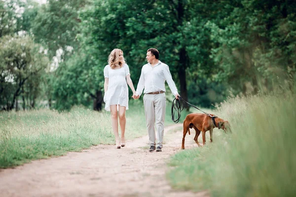 Joven marido y mujer hablan el tiempo para caminar en el parque — Foto de Stock