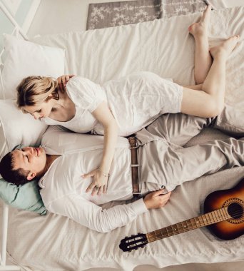 koca ve hamile karısı yatak odasında yatakta yatıyor