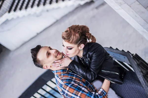Красивый парень целует свою девушку стоя на лестнице . — стоковое фото