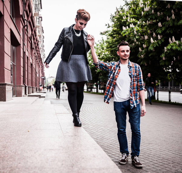 young lovers walking on the pavement in a European city