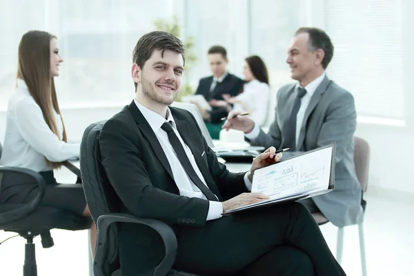 Hombre de negocios en la oficina con su equipo de negocios trabajando detrás —  Fotos de Stock