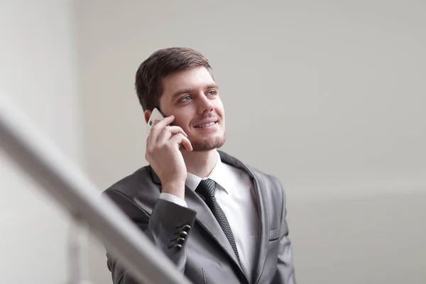 Cerrar up.smiling empresario hablando en el teléfono inteligente en la oficina — Foto de Stock