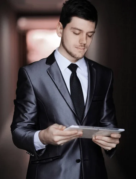 Close up. portrait of elegant businessman with digital tablet on office background — Stock Photo, Image