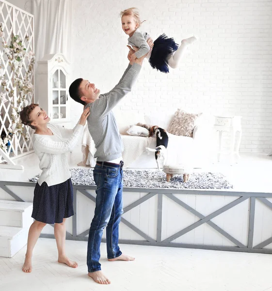 mother and father playing with his baby daughter in the bedroom. The concept of friendly family.