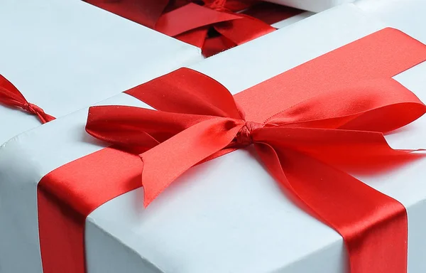 Elegantes cajas de regalo con cinta de satén rojo envueltas en papel . —  Fotos de Stock