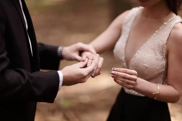 Fechar up.the noivo coloca o anel de casamento no dedo das noivas — Fotografia de Stock