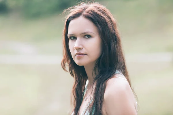 Retrato de uma bela jovem mulher contra o fundo da natureza — Fotografia de Stock