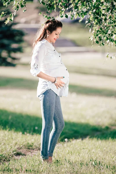 Felice donna incinta guardando la sua pancia — Foto Stock