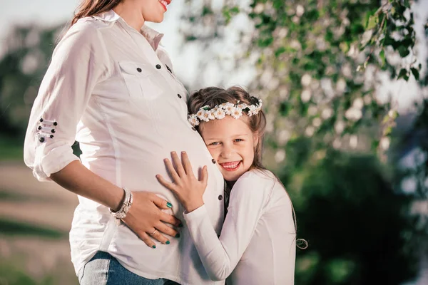 Bambina e la sua felice mamma incinta in una passeggiata nel parco estivo — Foto Stock