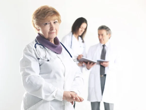 Взрослая женщина врач-терапевт на размытом фоне коллег — стоковое фото