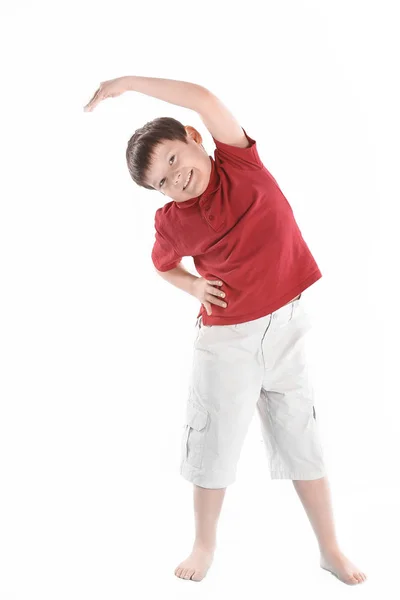 Liten pojke utför en övning för att sträcka ut muscles.isolated på vit — Stockfoto