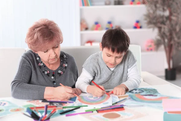 Großmutter und Enkel malen Regenbogen im Kinderzimmer — Stockfoto