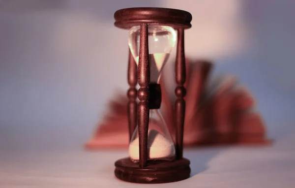 Libro abierto y hourglass.isolated sobre un fondo amarillo — Foto de Stock