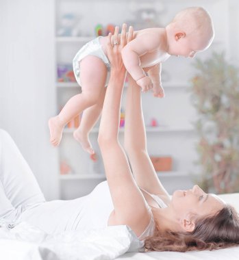 Genç Anne yatakta yatarken bebek çalış