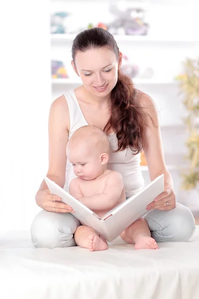 Encantadora mãe lendo um livro para seu bebê — Fotografia de Stock