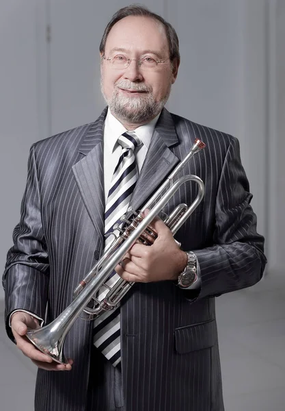 man in a gray suit with a trumpet