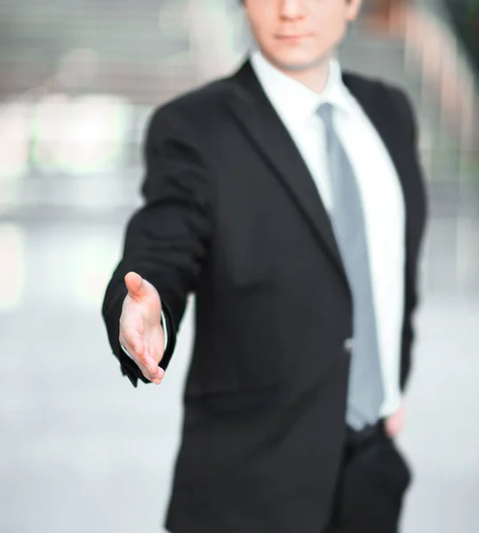 Bonito empresário dando a mão para um aperto de mão . — Fotografia de Stock