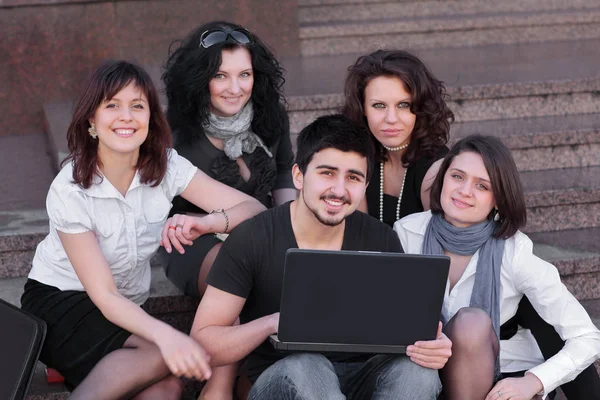 Groep vrienden van studenten met een laptop — Stockfoto