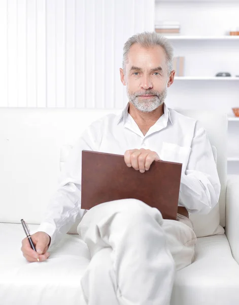 Senior businessman making a note in the workbook — Stock Photo, Image