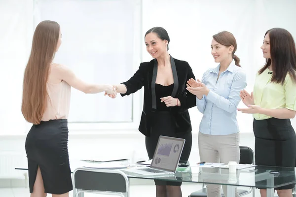Satisfied older woman and young manager handshaking after signing contract in office