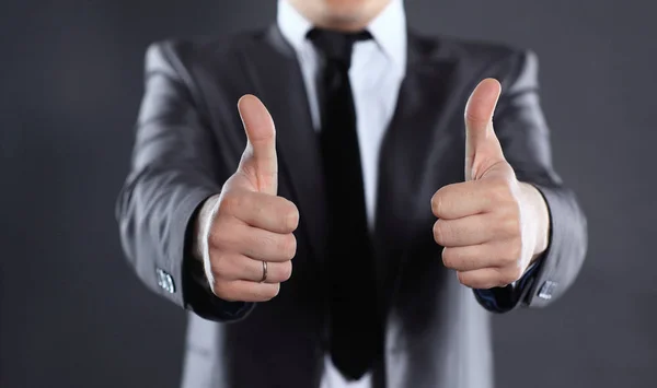 Close up.modern businessman showing thumbs up. isolated on black — Stock Photo, Image
