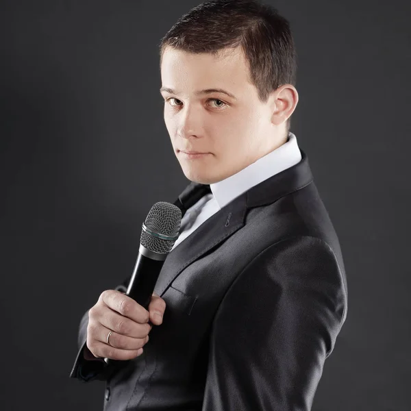 Joven empresario exitoso con microphone.isolated en negro — Foto de Stock
