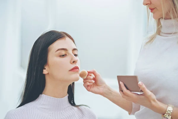 Make up artist doing professional make up of young woman — Stok Foto