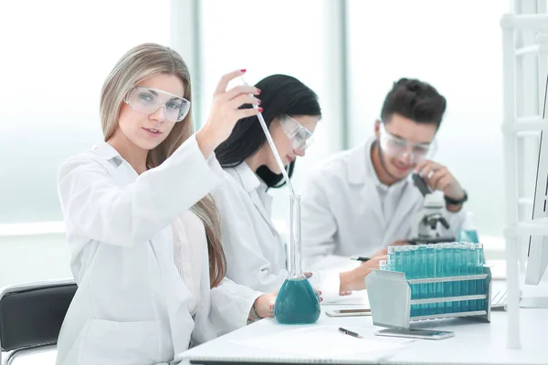 Close up.a team of scientists conduct fluid research — Stock Photo, Image