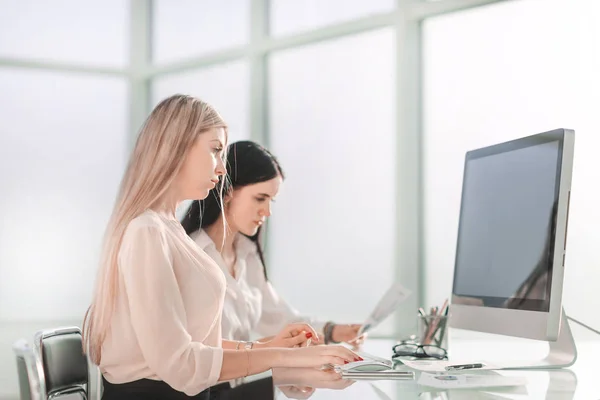 two employees sitting at the office Desk.