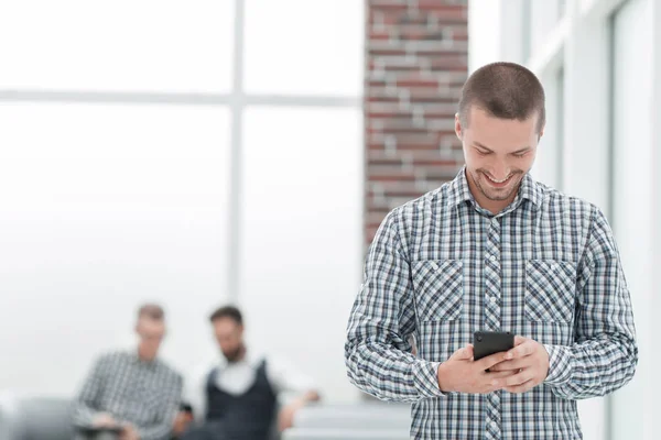 Young man reading a SMS on his smartphone — Stock Photo, Image