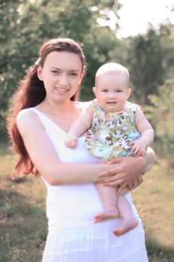 Anne ve mutlu kızı parkta bir yürüyüş üzerinde gülümseyen