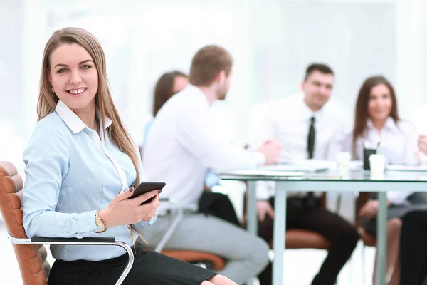 Ung anställd med en smartphone på bakgrunden av business-team — Stockfoto