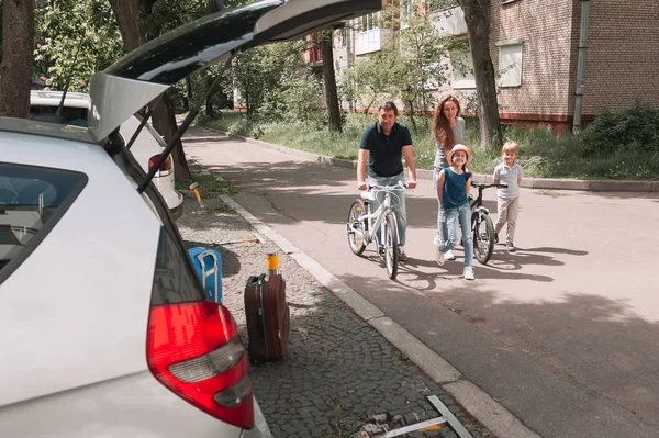 Rodina na kole jezdit na náměstí. — Stock fotografie