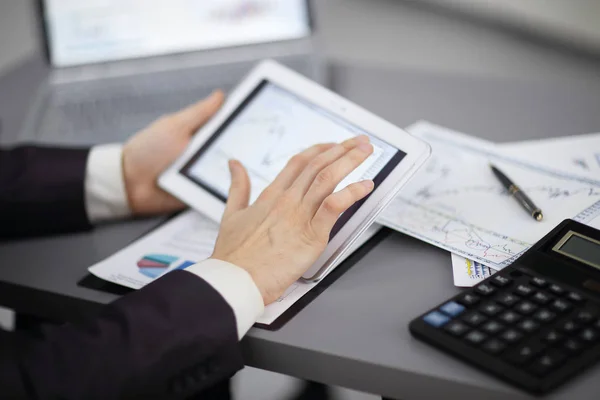 Close up.the empresario utiliza una tableta digital para trabajar con datos financieros — Foto de Stock