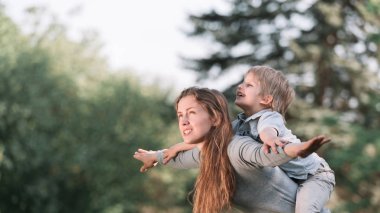 Parkta küçük oğluyla anne çalış.