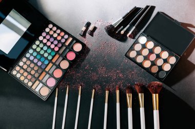 Makyaj fırçaları ve siyah arka plan üzerine göz farı.