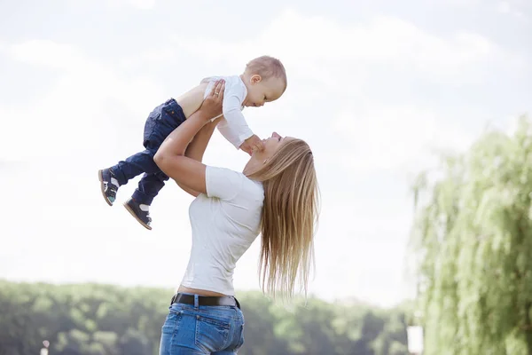 Madre juega con su hijo mientras camina en el parque — Foto de Stock