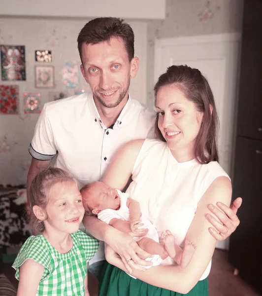 Retrato familiar - papá, hija y mamá con un bebé recién nacido — Foto de Stock