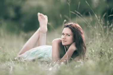 bir orman glade yatan sevimli genç kadın