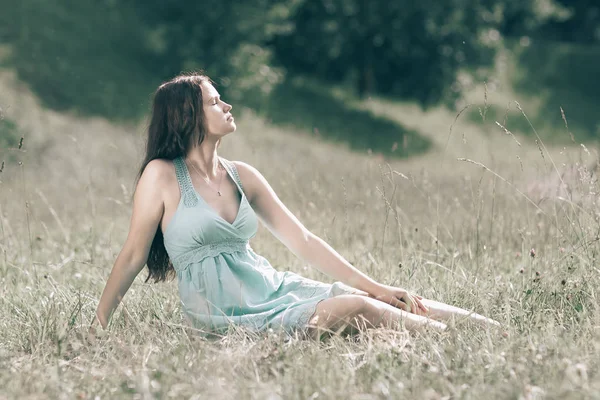 Hermosa joven sentada en el claro del bosque en el día de verano — Foto de Stock