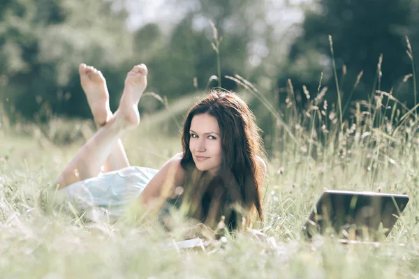 Modern söt flicka relaxavdelning på färskt gräs. — Stockfoto