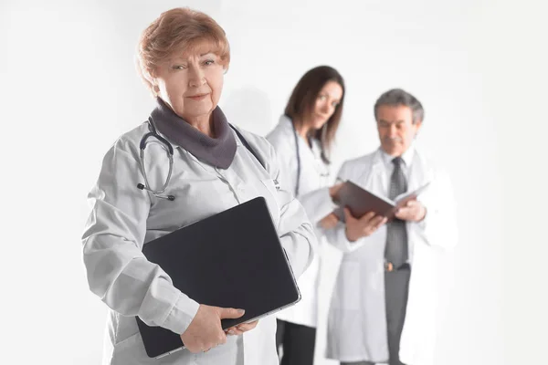 Terapeuta médico feminino com laptop no fundo borrado de colegas — Fotografia de Stock