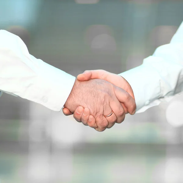 Närbild. Handshake affärsmän i suddig bakgrund. — Stockfoto