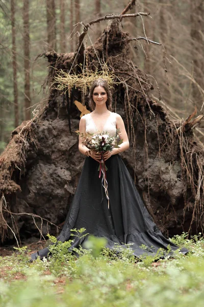 Vacker ung kvinna med bukett på bakgrund av skogen — Stockfoto