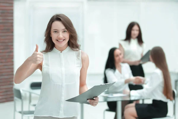 Självsäker ung affärskvinna med Urklipp på bakgrunden av business-team — Stockfoto