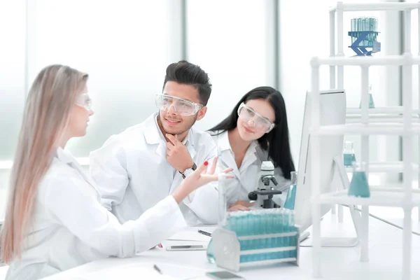 Team of scientists discussing something at the Desk — Stock Photo, Image