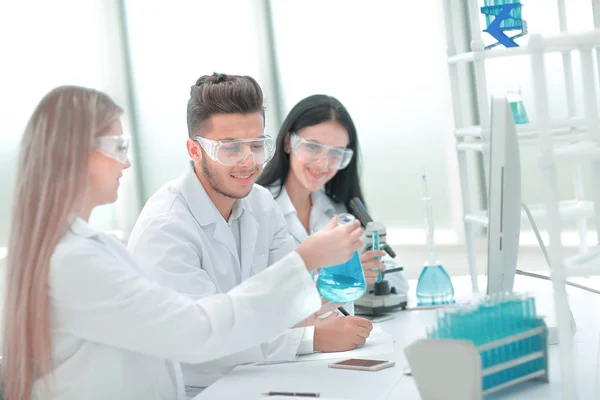 Close up.a team of scientists sitting at the laboratory table — Stock Photo, Image