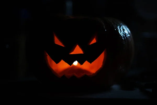 creepy smiling pumpkin for Halloween on black background.