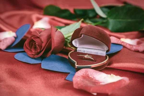 Anel de diamante e rosa no fundo vermelho brilhante — Fotografia de Stock