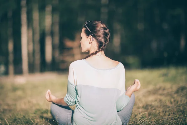 Vista trasera. mujer joven meditando en posición de Loto en Sunny Park —  Fotos de Stock